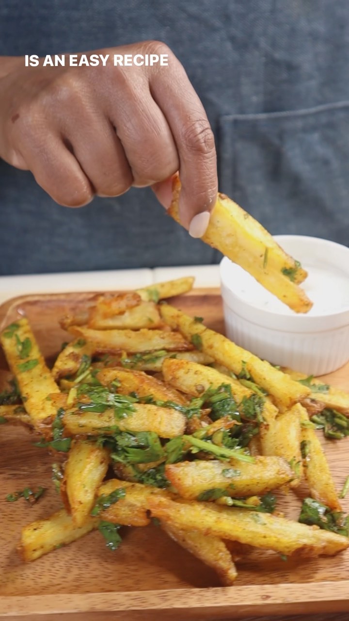 A person holding a knife over some food.