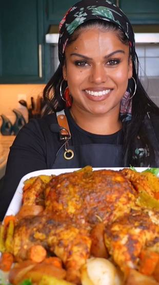 A woman holding a plate of food in front of her face.