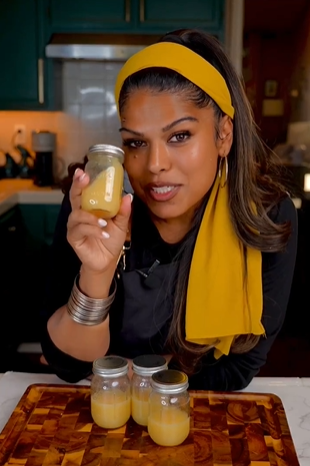 A woman holding a jar of mustard in her hand.