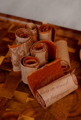 A wooden table with rolls of paper on it