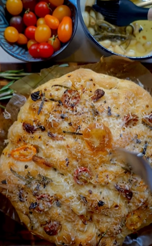 A pizza sitting on top of a pan next to some vegetables.