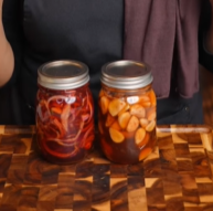 Two jars of food on a wooden table.