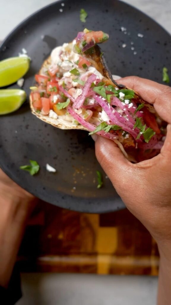 A person holding a plate with food on it.