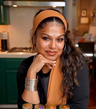 A woman with long hair wearing an orange scarf.