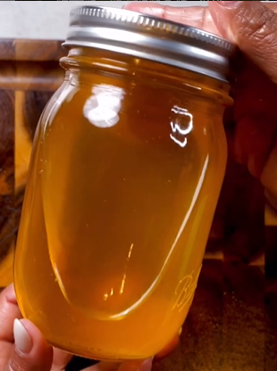 A person holding a jar of honey