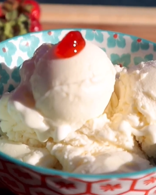 A bowl of ice cream with a cherry on top.