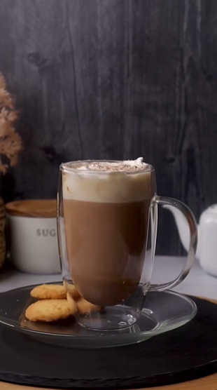 A cup of coffee with whipped cream and cookies.