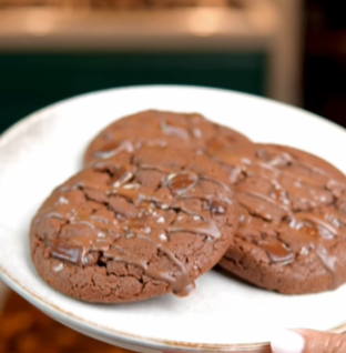 A plate of chocolate cookies on top of a table.