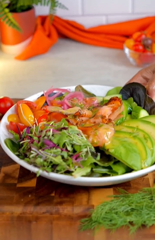 A white bowl filled with salad and shrimp.