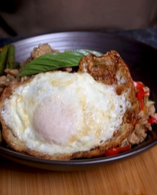 A plate of food with an egg on top.