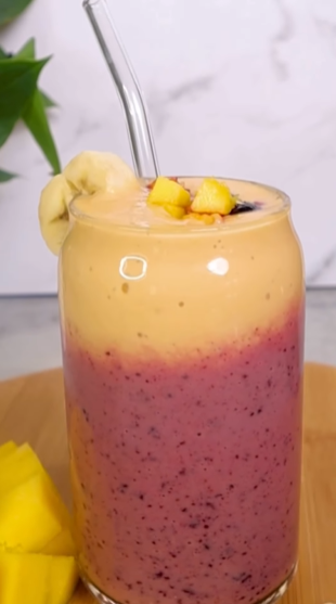 A smoothie with banana and blueberry in it.