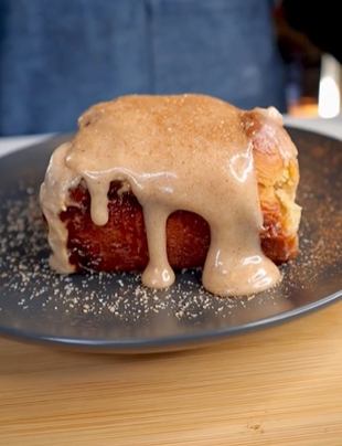 A piece of cake covered in icing on top of a plate.