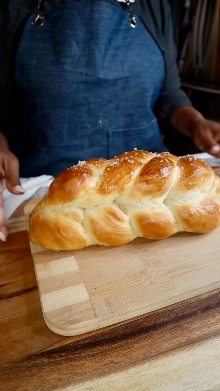 A loaf of bread on top of a wooden board.