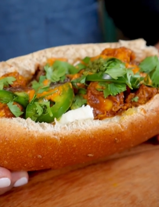 A close up of a sandwich with meat and vegetables