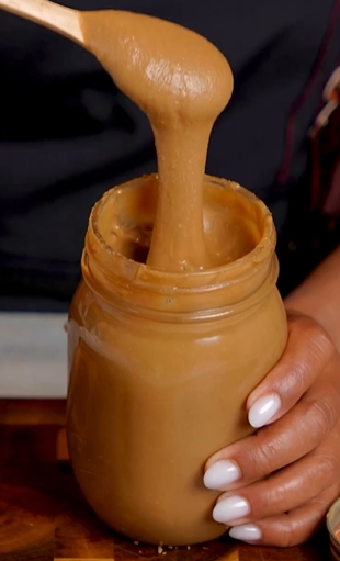 A person holding a jar of peanut butter