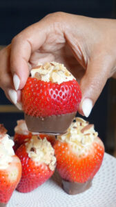 "Cheesecake-stuffed strawberries with chocolate coating and almond topping - easy no-bake dessert recipe